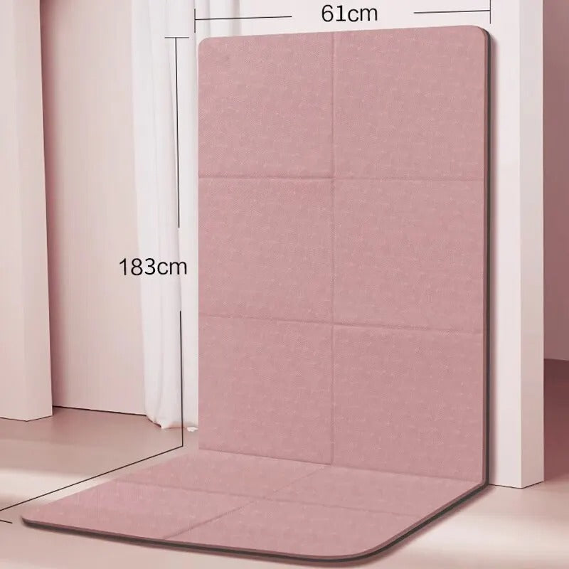Foldable gym mat with dimensions detail. Folded against a wall.