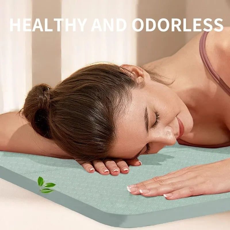 Woman lying her head on a green foldable gym mat.
