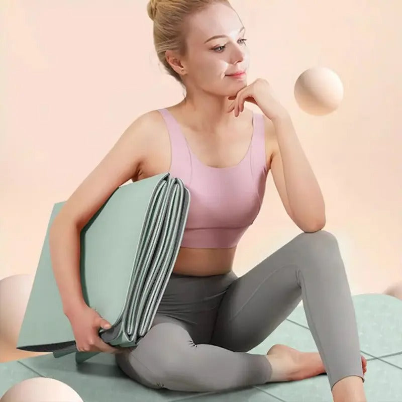 Woman in gym wear holding foldable gym mat.