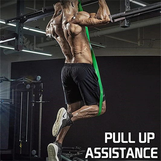 Muscular man training with green natural latex resistance band.