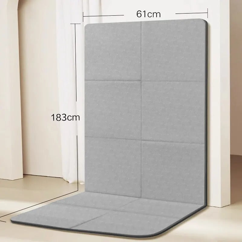 Foldable gym mat with dimensions detail. Folded against a wall.