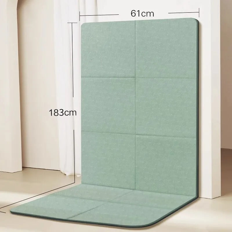 Foldable gym mat with dimensions detail. Folded against a wall. 
